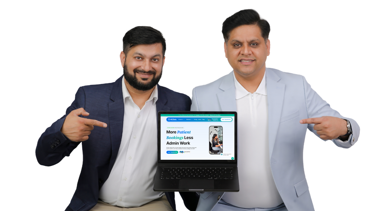 Dr. Varun Bajaj and Danish Wadhwa, co-founders of HiClinic, holding a laptop showing the HiClinic website